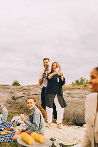 Woman taking selfie with male friend while enjoying in picnic