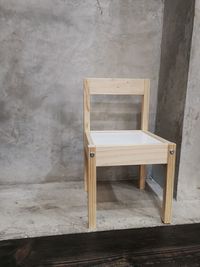 Empty chair and table against wall