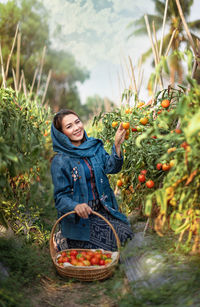 Portrait of smiling young woman with fruits in basket