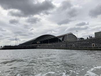 Bridge over river against sky in city