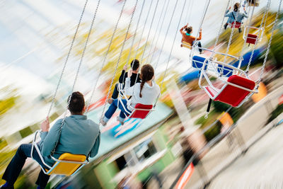 People riding carousel in amusement park