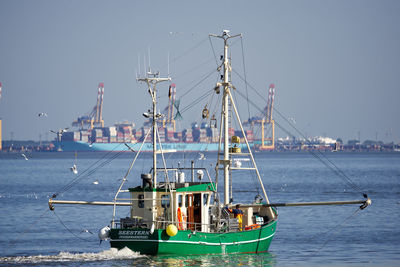 Sailboats moored on sea against sky