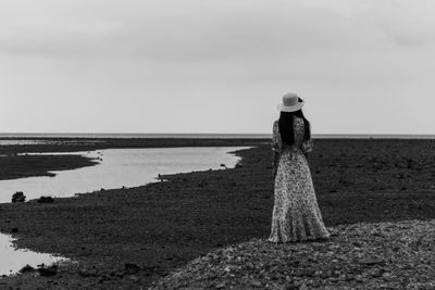 Depression concept black and white young woman standing alone on beach