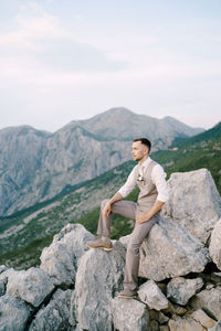 Full length of man standing on rock against sky