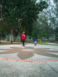 Rear view of women on footpath by trees