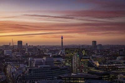 Aerial view of modern buildings against sky during sunset