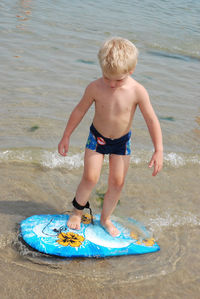 Full length of shirtless boy at beach