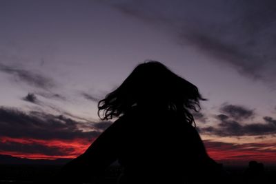 Silhouette woman against sky during sunset