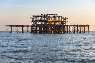 Pier over sea against sky during sunset