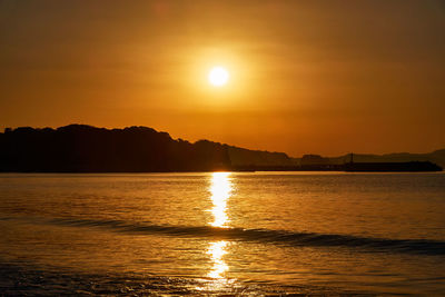 Scenic view of sea against romantic sky at sunrise