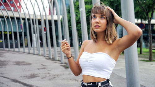 Teenage girl looking away while standing in city