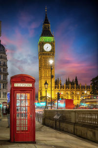 Clock tower amidst buildings in city at night