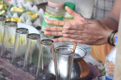 Cropped hands of woman preparing drink for sale