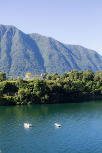 Scenic view of lake by mountains against clear sky