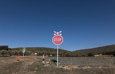 Stop sign of railway on field against sky. andalusia, spain