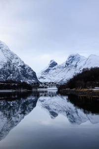 Scenic view of lake and snowcapped mountains against sky