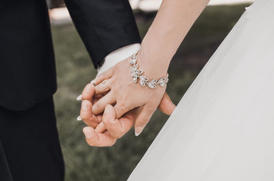 Midsection of couple holding hands