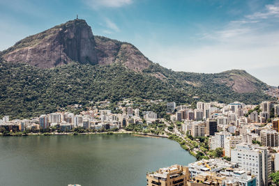 High angle view of cityscape by sea against mountains