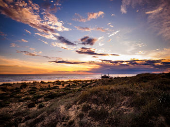 Scenic view of beach against sky during sunset