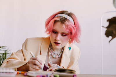 Portrait of young woman using mobile phone while sitting at home