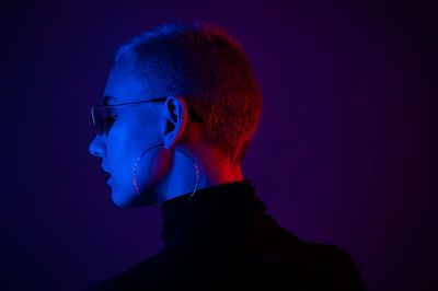 Close-up portrait of young man against blue background