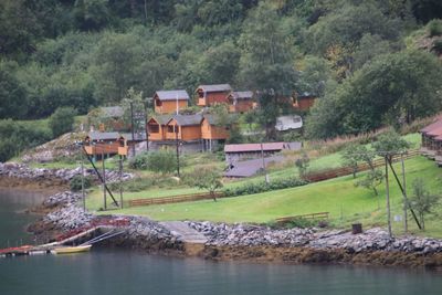 Scenic view of river by houses and trees