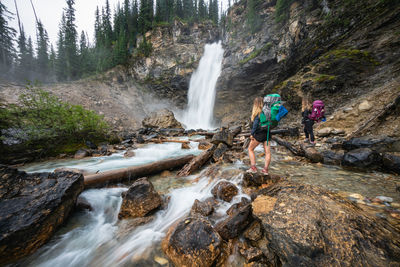 Hikers admiring laughing falls waterfall in yoho national park