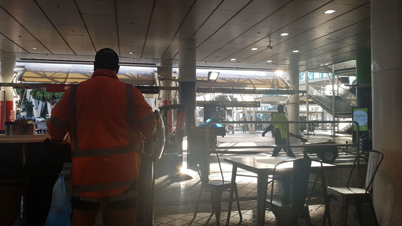 REAR VIEW OF MAN WORKING ON TABLE IN RESTAURANT