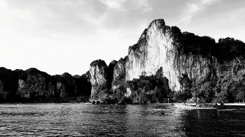 Rock formations by sea against sky