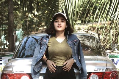 Portrait of woman standing against car