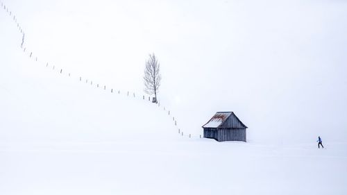 Building on field against clear sky during winter