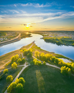 Scenic view of river against sky at sunset