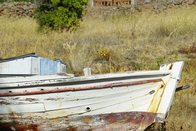 Abandoned boat moored on field