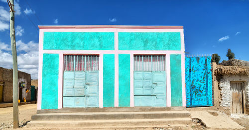 Closed door of building against blue sky