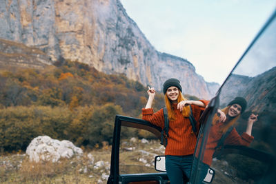 Portrait of young woman standing on mountain road