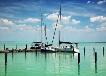 Sailboats in sea against sky