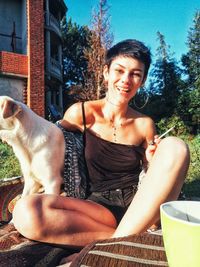Smiling young woman sitting outdoors