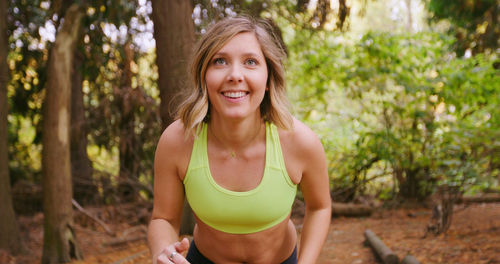 Portrait of smiling young woman in forest