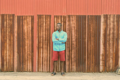 Portrait of man standing against wall