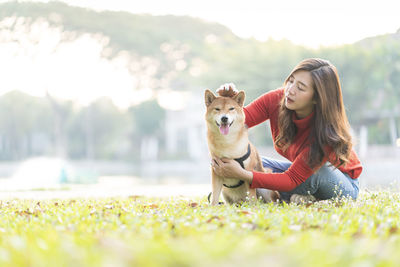 Pet lover concept. an asian girl is playing with a shiba inu dog. woman and dog hugging.