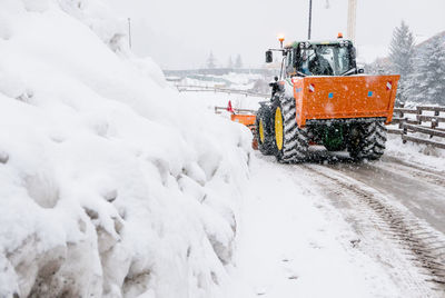 Snow covered road amidst field during winter