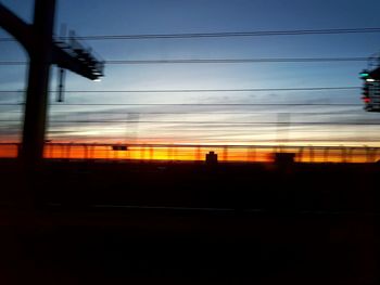 Silhouette of electricity pylon against sky