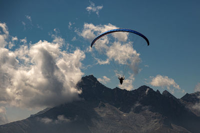 Low angle view of person paragliding against sky