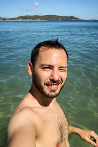 Portrait of young man smiling in sea