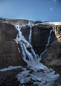 Scenic view of waterfall against sky during winter