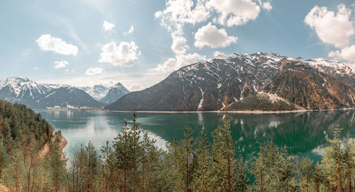 Scenic view of lake by mountains against sky