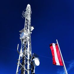 Low angle view of communications tower against clear blue sky