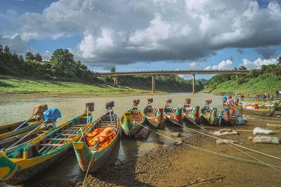 Boats moored in river against sky