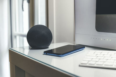 Smartphone, wifi speaker, router and computer on desk. technology, domotics, home automation concept