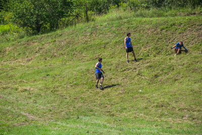 Rear view of men running on grassland
